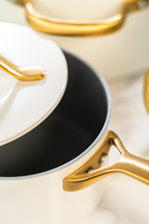 Angled view of a white-lidded enamel pot with metallic gold handle. Useful for branding or catalog use.の写真素材