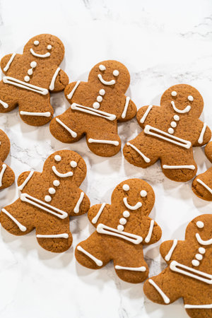 A collection of decorated gingerbread men cookies lined up neatly, highlighting their detailed royal...