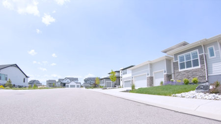 A suburban street in Castle Rock, Colorado featuring fresh landscaping, new homes, and a clear blue...