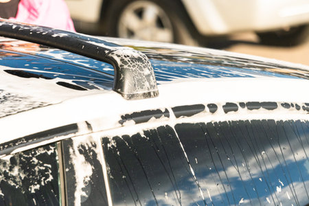 Efficiently cleaning an electric car in the comfort of a suburban driveway, combining eco-consciousness with practicality.の写真素材