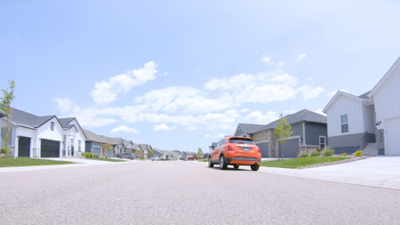 Parker, Colorado, USA-May 31, 2025 - Newly built houses along a clean residential street with an orange SUV parked outside. The day is sunny and the setting is peaceful and organized.のeditorial素材