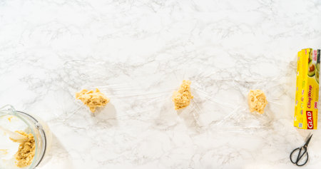 Dough divided onto cling wrap, ready to chill for Easter Cookie Sandwich with Raspberry Buttercream. Perfect for food preparation visuals and baking instruction content.の写真素材