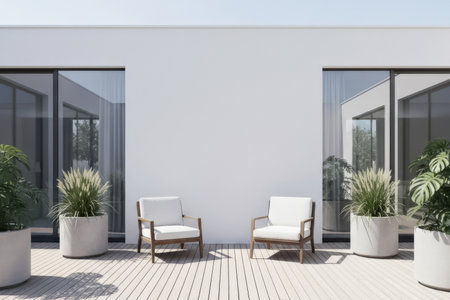 A minimalist outdoor patio design with white chairs and large potted plants is arranged against a clean white wall. The space is lit by natural daylight with a modern aesthetic.の素材
