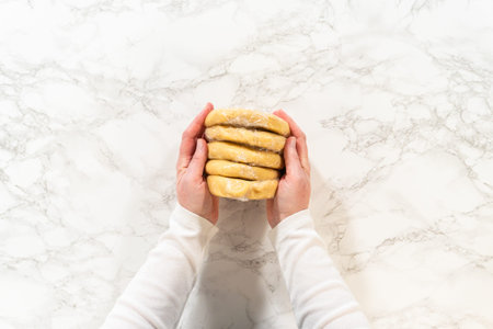 Hands holding wrapped dough disks for Easter Cookie Sandwich with Raspberry Buttercream. A great...