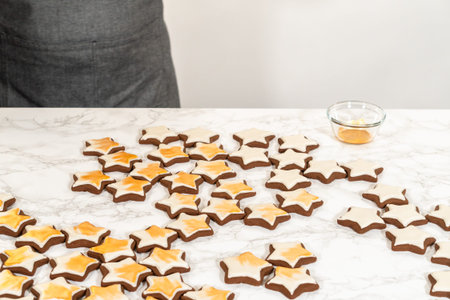 A wide spread of gingerbread star cookies arranged on a white surface, highlighting their intricate...