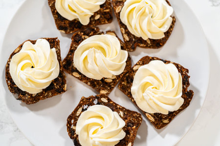 A top-down view of crispy gourmet crackers topped with elegantly piped whipped cream cheese. The...