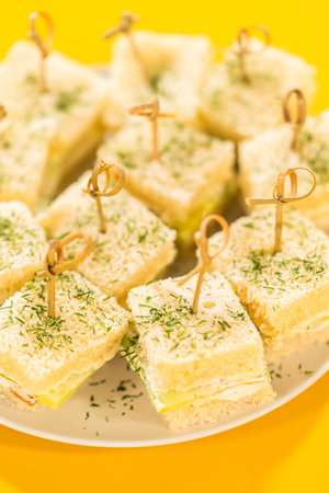 Delicate mini cucumber sandwiches made with fluffy white bread, a layer of herbed cream cheese, and...
