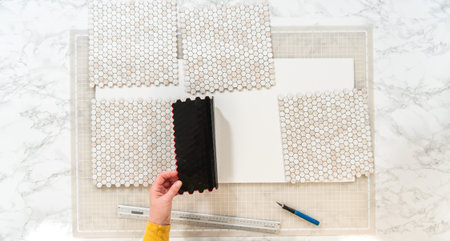 In the process of mounting peel and stick mosaic tiles onto a foam board, perfect for enhancing a...