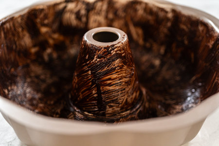 A Bundt pan coated with vegetable shortening and cocoa powder, creating a nonstick surface for the...