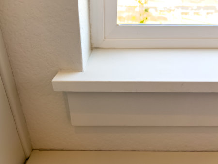 Straight-on view of a simple white window ledge and trim with natural daylight. Ideal for interior...