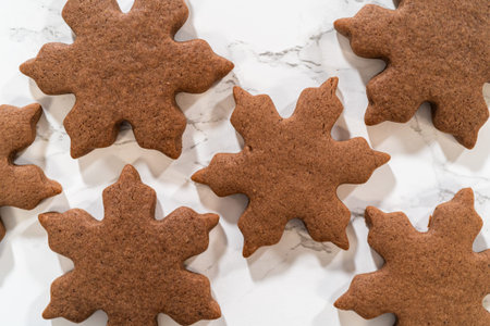 Grouped arrangement of three Chocolate Ginger Sugar Cookies in snowflake shapes on a marble surface,...