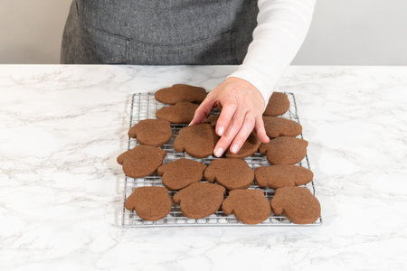 Front-facing view of freshly baked Pale Gingerbread Cookies shaped like mittens cooling on a wire...