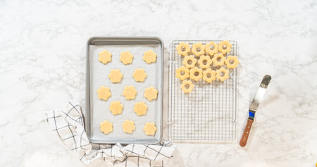 A collection of sugar cookies in flower shapes set to cool on a wire rack. Suitable for home baking...
