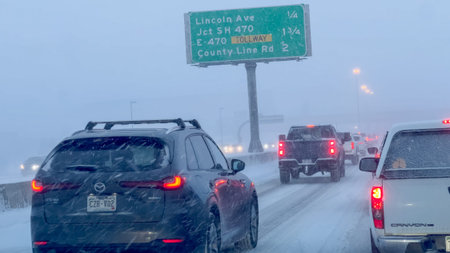 Parker, Colorado, USA-January 9, 2025 - A snowstorm slows traffic near a highway exit in Castle...