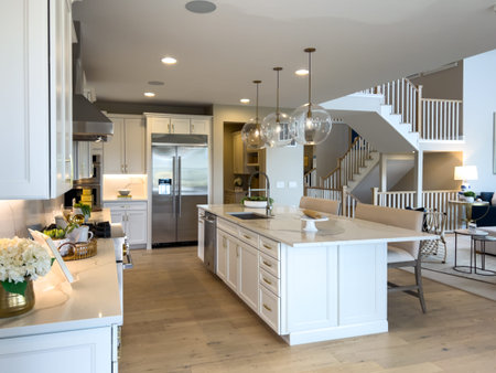 Castle Pines, CO, USA-October 6, 2025 - A contemporary kitchen with white cabinetry, pendant lights...