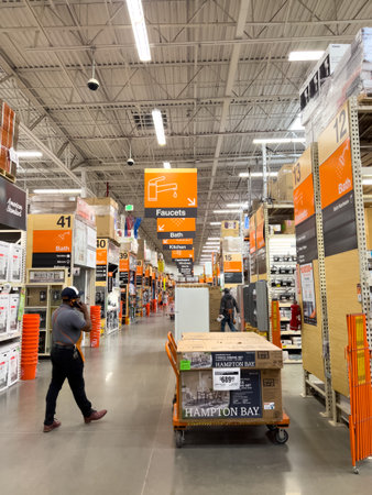 Parker, Colorado, USA-April 27, 2025 - The main central walkway of a Home Depot store with visible aisle signs and shoppers browsing. Overhead lights brighten the stores high ceilings.