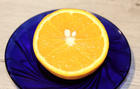 half an orange on a blue plate