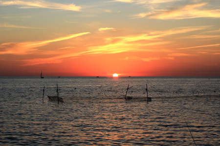 fishing nets in the sea on the background of a beautiful sunsetの写真素材