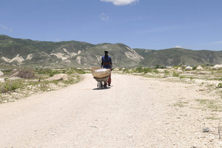 PORT-AU-PRINCE - AUGUST 30: A construction worker carrying rubble in one of the tent city , in...