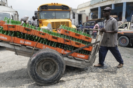 PORT-AU-PRINCE - AUGUST 21: A man carrying empty crates of drinks on a cart in the Iron Market in Port-Au-Prince, Haiti on August 21, 2010.のeditorial素材