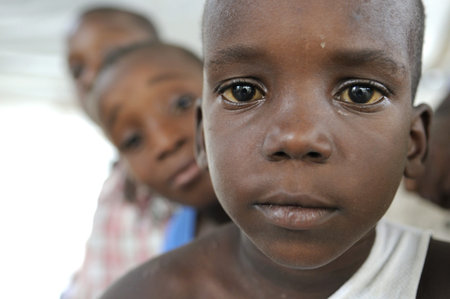 PORT-AU-PRINCE - AUGUST 22: unidentified Haitian kids looking over the shoulder of each other during a food distribution camp in Port-Au-Prince, Haiti on August 22, 2010.のeditorial素材