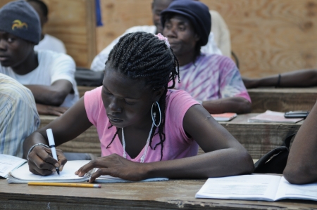 CITE SOLEIL- AUGUST 25: A female student taking notes in a local community school in Cite Soleil- one of the poorest area in the Western Hemisphere on August 25 2010 in Cite Soleil, Haiti.のeditorial素材