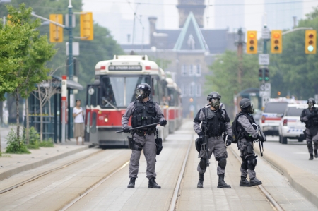 TORONTO-JUNE 27: Elite police personnel with gas masks protecting the street car tracks during the G20 Protest on June 27, 2010 in Toronto, Canada.のeditorial素材