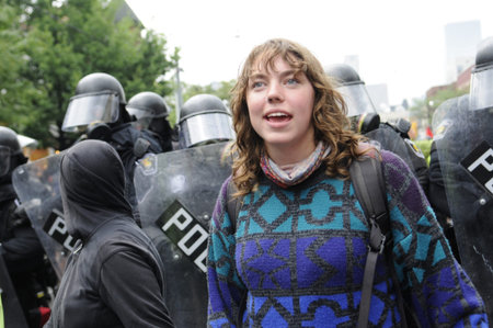 TORONTO-JUNE 26: A protester chanting slogans while being surrounded by the riot police officers...