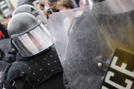 TORONTO-JUNE 26: Toronto police officer standing in between a volatile protest during the G20 Protest on June 26 2010 in Toronto, Canada.のeditorial素材