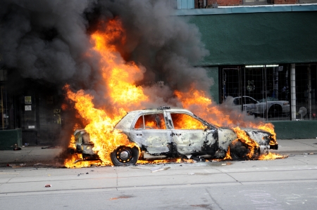 TORONTO-JUNE 26: A police car burning after being torched by the protesters during the G20 Protest on June 26, 2010 in Toronto, Canada.のeditorial素材