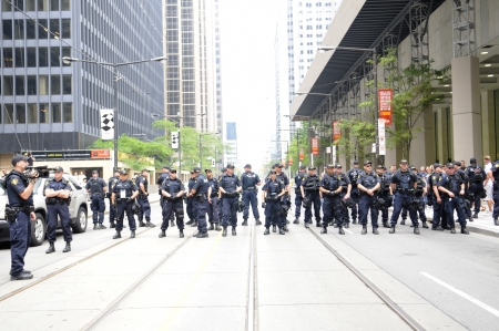 TORONTO-JUNE 27: Police officers protecting the core downtown by forming human barricades during the G20 Protest on June 27, 2010 in Toronto, Canada.のeditorial素材