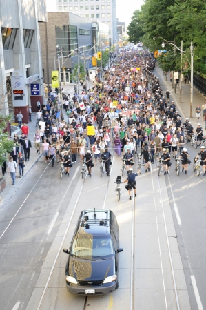 TORONTO-JUNE 28: A police patrol car guiding a huge rally of activists during the G20 Protest on June 28, 2010 in Toronto, Canada.のeditorial素材