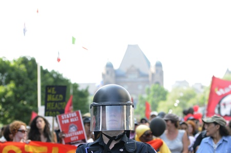 TORONTO-JUNE 25: A Police officer wearing protective helmet guiding a huge rally through the streets of Toronto during the G20 Protest on June 25, 2010 in Toronto, Canada.のeditorial素材