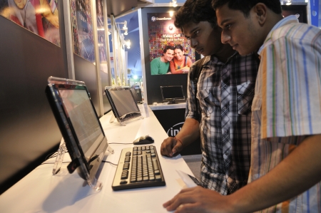 KOLKATA- FEBRUARY 20: Young teens looking at the HP DreamScreen, during the Information and Communication Technology (ICT) conference and exhibition in Kolkata, India on February 20, 2011.のeditorial素材