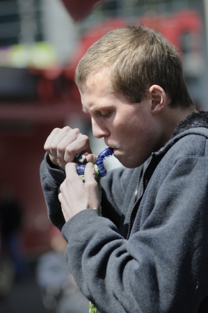 TORONTO - APRIL 20: A young man lighting his metal marijuana pipe during the annual marijuana 420 event at Yonge & Dundas Square on April 20 2012 in Toronto, Canada.のeditorial素材