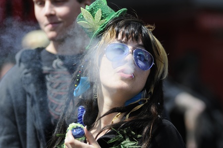 TORONTO - APRIL 20: A Marijuana smoker blowing off smoke during the annual marijuana 420 event at Yonge & Dundas Square on April 20 2012 in Toronto, Canada.のeditorial素材