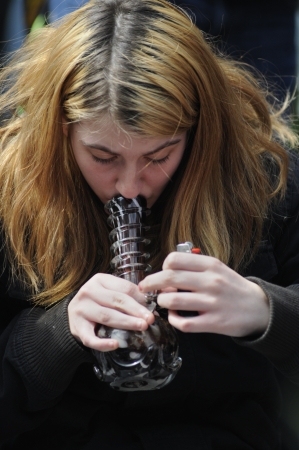 TORONTO - APRIL 20: A marijuana smoker smoking during the annual marijuana 420 event at Yonge & Dundas Square on April 20 2012 in Toronto, Canada.のeditorial素材