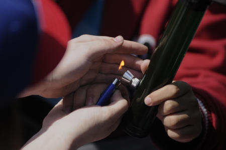 TORONTO - APRIL 20: Human hands lighting and guarding the flame to light a marijuana bong during the annual marijuana 420 event at Yonge & Dundas Square on April 20 2012 in Toronto, Canada.のeditorial素材
