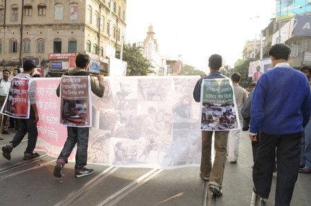 KOLKATA- DECEMBER 20: Marchers walk along the street with the images of the victims killed during the electoral confrontation during a silent rally in Kolkata, India on December 20, 2010.のeditorial素材