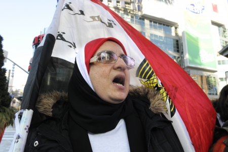 TORONTO - JANUARY 21: A old Egyptian woman chanting slogans in a rally at Yonge and Dundas square during the global day of support for the Egyptian revolution on January 21 2012 in Toronto, Canada.のeditorial素材