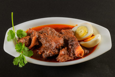 Spicy Chicken Curry, with sliced boiled eggs, garnished with coriander leaves. It is a favorite...