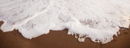 waves and sand on the beachの写真素材