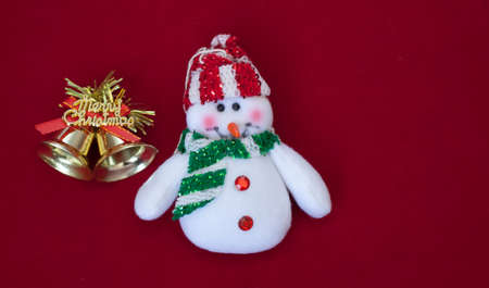 White snowman with gold merry christmas bells on red backgroundの写真素材