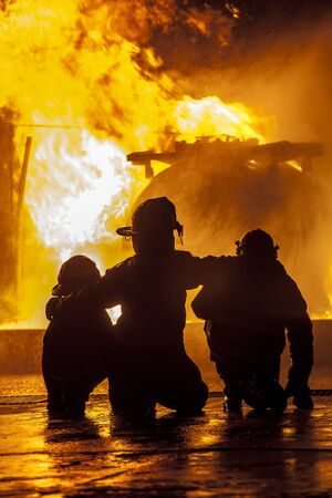 Firefighters watching a fire burnの写真素材