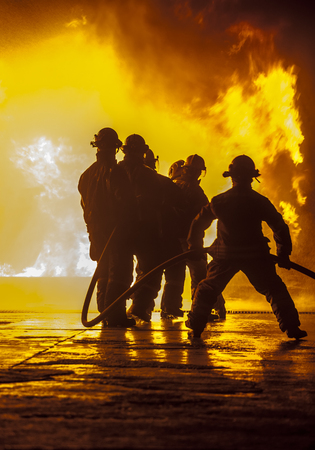Firefighter bracing during firefightingの写真素材