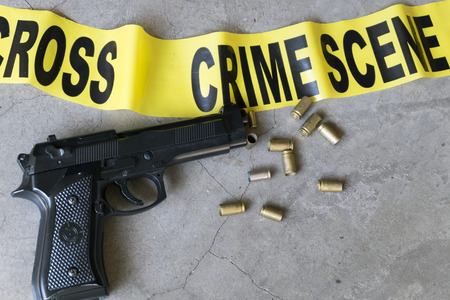 Crime scene concept with bullet casings and black gunの写真素材