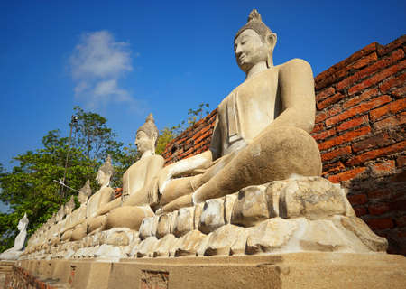 Travel Thailand - Buddha statue in Wat Yai Chaimongkol on blue sky and cloud background, Ayutthaya Historical Park. The brick pagoda at old ayutthaya temple ruins. Space for text in template.の写真素材
