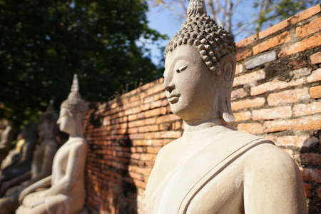 Travel Thailand - Buddha statue in Wat Yai Chaimongkol on blue sky and cloud background, Ayutthaya Historical Park. The brick pagoda at old ayutthaya temple ruins. Space for text in template.の写真素材