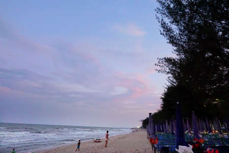 PRACHUAP KHIRI KHAN, THAILAND - APRIL 20, 2018 : People playing the sea at cha am beach. Many tourists visit here, View for seascape at  twilight times. Space for text in template.のeditorial素材