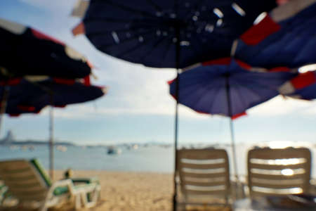 Blurred for background of Beach chairs with umbrella on beautiful beach and sea at Pattaya,Thailand. Seats on the sea beach,Summer holiday and vacation concept for tourism. abstract background.の写真素材